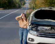 Upset young woman driver talking angrily on cell phone with assistance service near a broken car with open hood while inspecting engine having trouble with her vehicle → Green Country Federal Credit Union Do you have an emergency fund